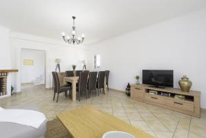 a living room with a dining table and a television at Villa Menina by Ocvillas in Albufeira