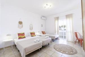 a white bedroom with two beds and a living room at Villa Menina by Ocvillas in Albufeira +34 photos