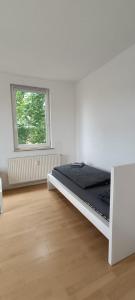 een witte kamer met een bed en een raam bij Ferienwohnung Roko in Eisenach