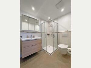 a bathroom with a shower and a toilet and a sink at Haus Petje in Keitum +32 photos