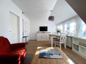 een woonkamer met een rode bank en een tafel bij Haus Petje in Keitum