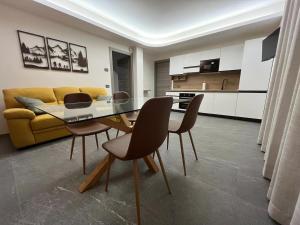 a living room with a dining table and a yellow couch at La Coccinella vacation home in Druogno