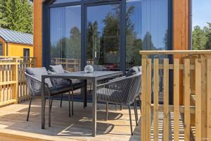 a patio with a table and chairs on a deck at First Camp Skara Sommarland in Axvall