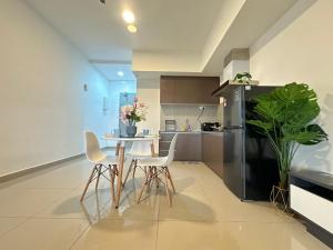 a kitchen with a table and chairs and a refrigerator at Alinea suites Luxury near by shah alam in Shah Alam