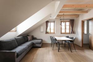 a living room with a couch and a table at Schmitte am Sonnenwirtsplatz, perfect starting point for bike and hike in Appiano sulla Strada del Vino