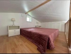 una camera da letto con un letto con copriletto rosso e una finestra di Comfortable private guesthouse 