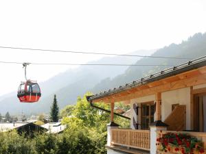 a red cable car flying over a house at Hotel Kaiserhof Kitzbühel, 4 Sterne Superior in Kitzbühel