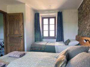 a bedroom with two beds and a window at Historic Wine-Stone House in Vipava +23 photos