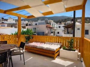 a bed on a patio with a table and chairs at Jasmine Summer House in Kalo Chorio