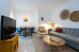 a living room with a couch and a tv and a table at 1 Bedroom apt with pool access in Albufeira