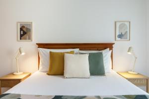 a bedroom with a white bed with two lamps at 1 Bedroom apt with pool access in Albufeira +18 photos