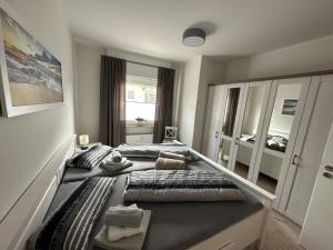 a bedroom with two beds and a large mirror at Leuchtturmblick in Borkum