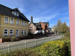a row of houses with a white fence at Leuchtturmblick in Borkum