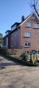 un edificio de ladrillo con una estatua delante de él en Baalmann Nr3, en Borkum
