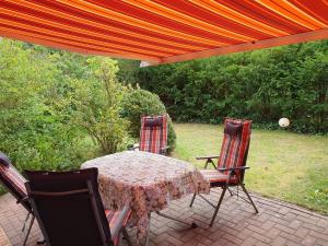 una mesa de patio con sillas y una sombrilla naranja en Haus Bremers Hafen, en Borkum