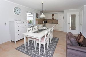 a kitchen and dining room with a white table and chairs at Sandburg in Borkum