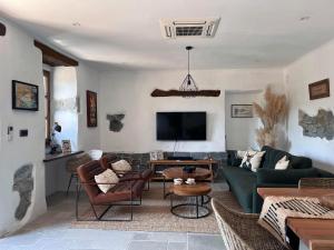 a living room with a couch and a tv at Historic Wine-Stone House in Vipava