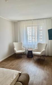 a living room with two chairs and a table at Проста і затишна квартира! Бульвар Шевченко in Cherkasy