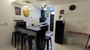 a kitchen with black stools and a black refrigerator at Teratak Kencana Impian Islamic Only in Sungai Lalang
