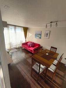 a living room with a red couch and a table at Hermosa Vista La serena in La Serena
