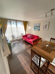 a living room with a red couch and a table at Hermosa Vista La serena in La Serena