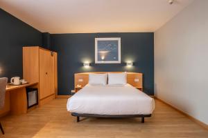 a bedroom with a bed and a blue wall at Travelodge Murcia in Murcia