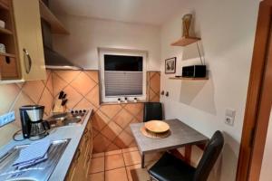 a small kitchen with a small table and a sink at Baalmann Nr.2 in Borkum