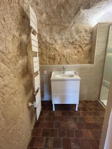 a bathroom with a sink and a mirror at Habitat troglodyte typique et confortable in Villaines-les-Rochers