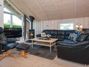 a living room with a leather couch and a table at 4 star holiday home in Hemmet in Hemmet