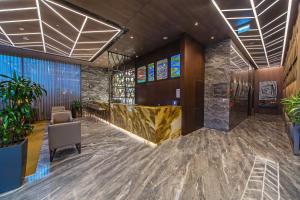 a lobby with a waiting area with plants and stained glass windows at Naz City Hotel Taksim - Special Category in Istanbul