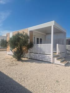 a house with a porch and stairs in front of it at Camping Resort Šibenik in Razvala