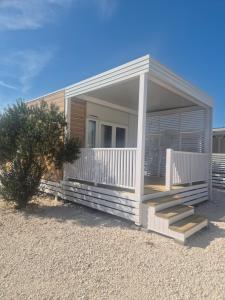 a small house with a porch and stairs on it at Camping Resort Šibenik in Razvala