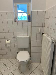 a bathroom with a white toilet and a window at Gemütlich wohnen in Blankenstein am Rennsteig  +16 photos