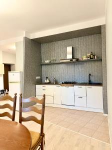 une cuisine avec des armoires blanches et une table et des chaises dans l'établissement DICTUMFACTUM Niguliste Charm Apartment, à Tallinn