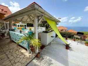 une terrasse avec un pavillon et une piscine dans l'établissement VILLA PASKEDRA, à Case-Pilote