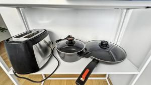 a pot and a toaster sitting on a shelf at Cute studio in the center - Crown 42 in Zürich +2 photos