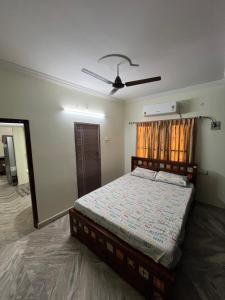 Un dormitorio con una cama y un ventilador de techo. en Happy living, en Gunadala