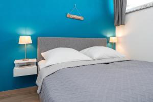 a blue bedroom with a bed and a blue wall at Baltic 117 Grömitz in Grömitz