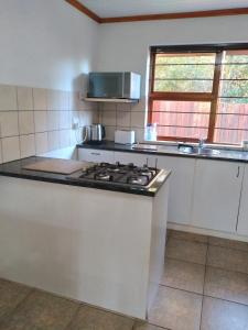 a kitchen with a stove and a counter top at Bush Beach Safari Accommodation in Jeffreys Bay +11 photos