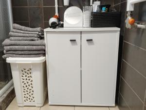 a white bathroom cabinet with a mirror on top at Sole Mio Apartment in Szeged +8 photos