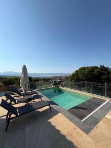 a swimming pool with two lounge chairs and an umbrella at La Casa San Biaggio in Ajaccio