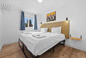 レミントン・スパにあるNEW! 6BR Gem, By Clarendon Stays, Free Parking, Perfect For Groupsの木製のヘッドボードが付いた大きな白いベッドのある寝室