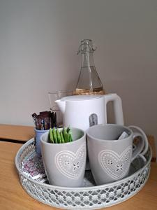 bandeja con tazas y tetera sobre una mesa en Chambre Les Terrasses de Condate, en Rennes