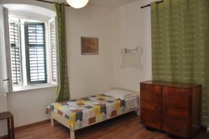a bedroom with a bed and a dresser and a window at Apartments Elettra in Umag