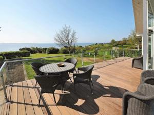 eine Terrasse mit Tisch und Stühlen auf einem Deck in der Unterkunft Seaside Bliss in Fyn - By Traum Ferienwohnungen in Bøjden