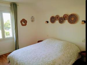 a bedroom with a bed and some plates on the wall at Appartement en Corrèze in Le Lonzac