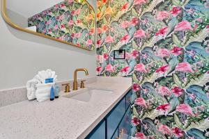 La salle de bains est pourvue d'un lavabo et de papier peint à fleurs. dans l'établissement Milo's Beach Bungalow, à Santa Rosa Beach 55 autres photos