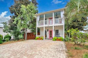 une grande maison blanche avec une porte rose dans l'établissement Milo's Beach Bungalow, à Santa Rosa Beach