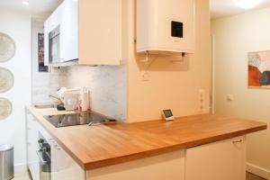 a kitchen with a sink and a wooden counter top at bright studio with balcony quiet location in Paris