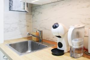 a kitchen counter with a mixer and a sink at bright studio with balcony quiet location in Paris